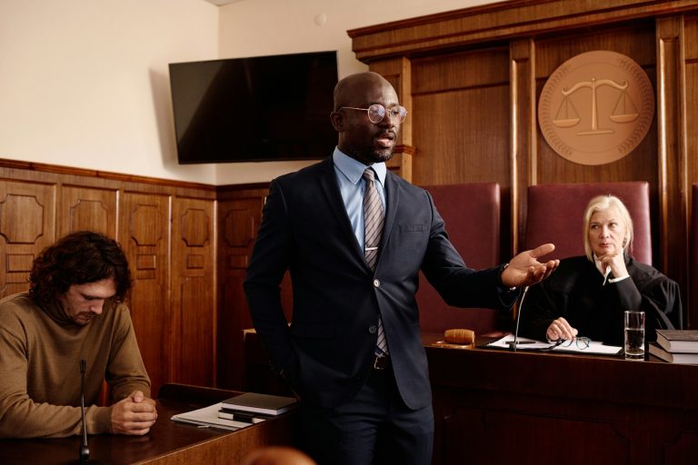 Confident attorney in formalwear speaking to prosecution side during trial