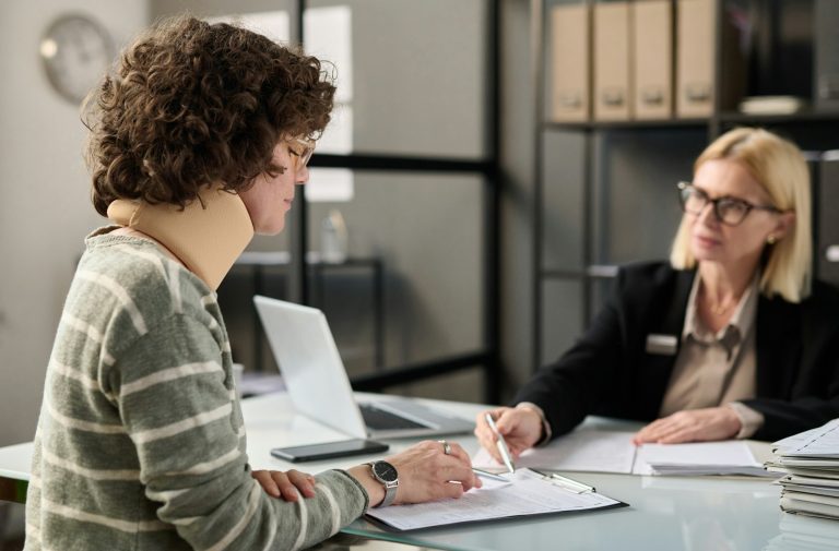 Young woman with neck injury filling documents