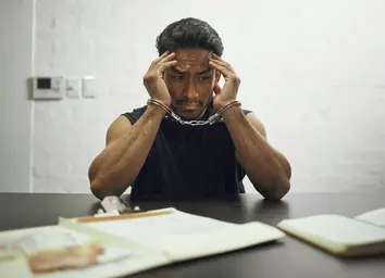 A fearful man in handcuffs facing interrogation, representing Civil Rights Law in Philadelphia.